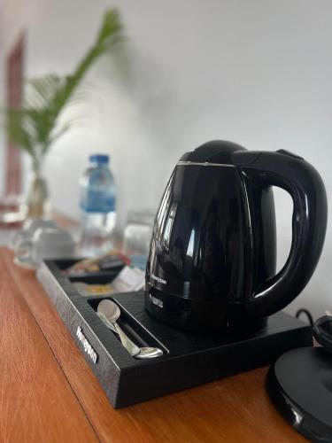a black coffee cup sitting on top of a table at The Moon Kampot Boutique in Kampot