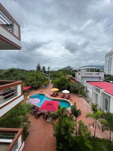 an overhead view of a swimming pool with umbrellas and tables at The Moon Kampot Boutique in Kampot