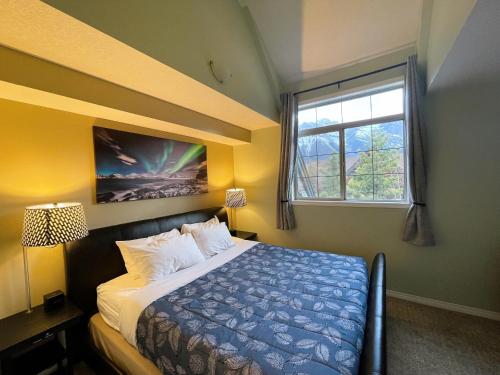 Schlafzimmer mit einem Bett und einem Fenster in der Unterkunft Renovated Chalet at Mystic Springs, Mountain Views, Pets Welcome! in Canmore
