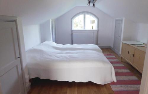 a white bedroom with a bed and a window at Cozy Home In Kvicksund With Sauna in Kvicksund