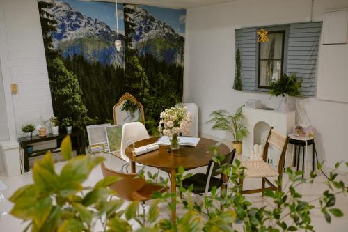 una sala da pranzo con tavolo, sedie e murale di Inhere Guesthouse a Gyeongju