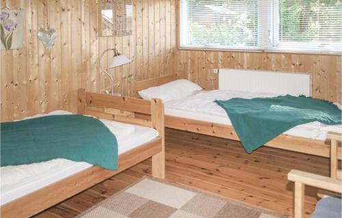 two beds in a room with wooden walls at Gorgeous Home In Dorf-zechlin With Kitchen in Zechlin Dorf