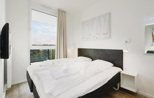 トラフェミュンデにあるNice Apartment In Lbeck Travemnde With 2 Bedrooms, Sauna And Wifiの窓付きの客室の白いベッド1台