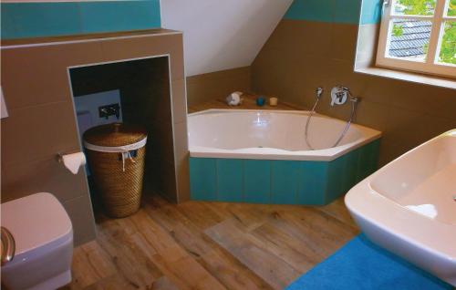 a bathroom with a tub and a toilet and a sink at Haus Nixe in Börgerende-Rethwisch