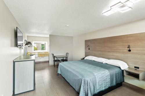 a hotel room with a bed and a kitchen at Siesta Inn McAllen in McAllen