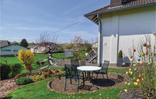 a patio with a table and chairs in a yard at Nice Apartment In Körperichobersgegen in Körperich