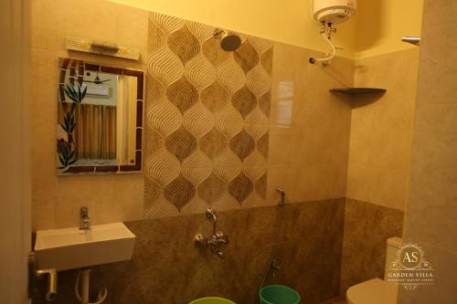 a bathroom with a sink and a toilet and a mirror at AS Garden Villa in Ranipet