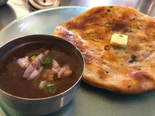 une assiette avec un bol de soupe et un morceau de pain dans l'établissement Roop Niwas, à Amritsar