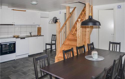 Una cocina y un comedor con una mesa y una escalera. en Stunning Home In Löttorp With Wifi, en Löttorp