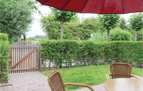 a table and chairs with a red umbrella on a patio at 3 Bedroom Amazing Apartment In Paessens in Paesens
