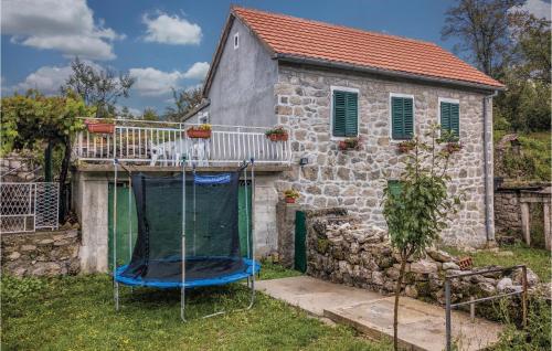 a house with a trampoline in front of it at 2 Bedroom Stunning Home In Herceg Novi in Sitnica
