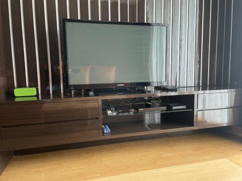 a large entertainment center with a flat screen tv at 2BR Lovely Condo Amazing City View Lexington Residence in Jakarta
