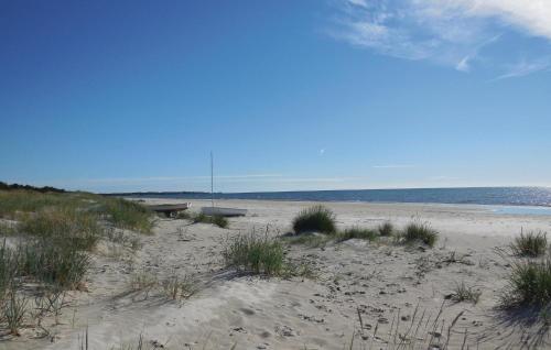a sandy beach with a bench and the ocean at 3 Bedroom Pet Friendly Home In Borrby in Borrby