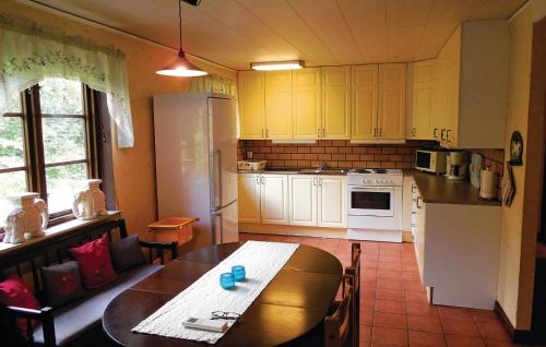 Il comprend une cuisine équipée d'une table et d'un réfrigérateur blanc. dans l'établissement 3 Bedroom Pet Friendly Home In Borrby, à Borrby