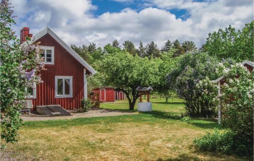 a red house with a yard with trees at Amazing Home In Läckeby in Gärdsholmen