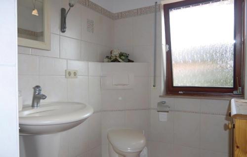 a bathroom with a sink and a toilet and a window at 1 Bedroom Awesome Apartment In Schnecken in Wetteldorf