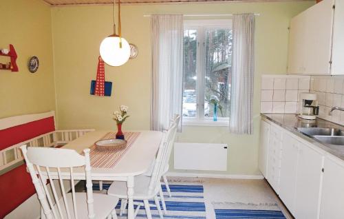 une cuisine avec une table et des chaises ainsi qu'une fenêtre dans l'établissement 2 Bedroom Amazing Home In Slvesborg, à Möllebjörke
