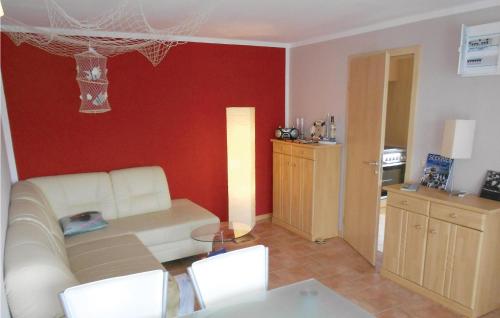 a living room with a white couch and a red wall at Holiday Home Dranske Alte Gärtnerei in Dranske