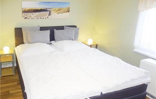 ein Bett mit weißer Bettwäsche und Kissen in einem Schlafzimmer in der Unterkunft Awesome Home In Insel Poel-timmendorf With 1 Bedrooms in Timmendorf