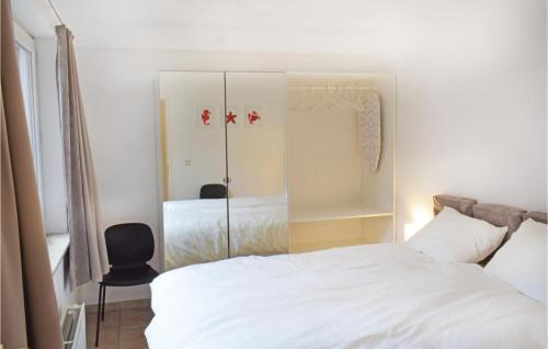 een slaapkamer met een wit bed en een stoel bij Sun Garden in Oostende