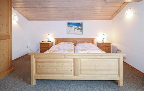 ヴァルヒゼーにあるNice Apartment In Walchsee With 3 Bedrooms And Wifiのベッドルーム1室(木製ベッド1台、ナイトスタンド2台付)