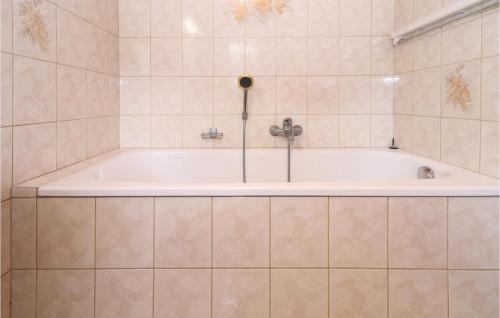 eine Badewanne im gefliesten Bad in der Unterkunft Nice Apartment In Walchsee With 3 Bedrooms And Wifi in Walchsee