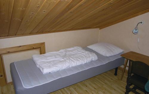 Bett mit weißer Bettwäsche in einem Zimmer mit Holzdecke in der Unterkunft Amazing Home In Vaggeryd With 3 Bedrooms And Wifi in Ödestugu