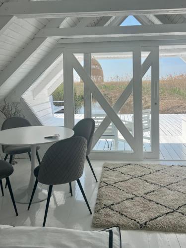 a room with a table and chairs and a window at Seehütte Neusiedlersee - Strandhaus, Elektroboot inklusive in Rust