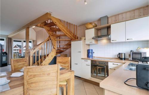 a kitchen with white cabinets and a wooden staircase at Nice Apartment In Rechlin With Wifi in Rechlin