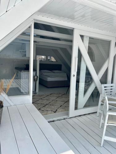 a screened porch with sliding glass doors on a deck at Seehütte Neusiedlersee - Strandhaus, Elektroboot inklusive in Rust