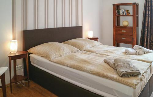 ヴァーネミュンデにあるAwesome Apartment In Warnemnde With 1 Bedrooms And Wifiのベッドルーム1室(大型ベッド1台、ナイトスタンド2台付)