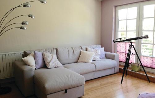 a living room with a white couch and a camera at Awesome Home In Beckerwitzhohenkirchen in Hohenkirchen