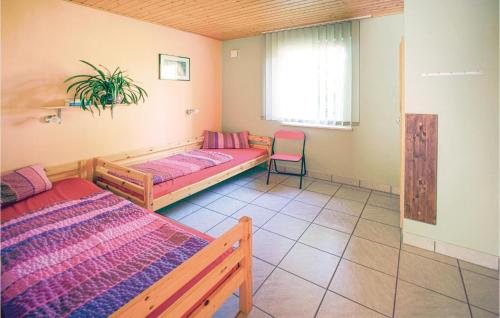 ein Zimmer mit 2 Betten und einem Stuhl darin in der Unterkunft Ferienhaus Am Rodelberg H in Priborn