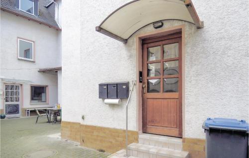 eine Holztür in einem weißen Gebäude mit einem Mülleimer in der Unterkunft 1 Bedroom Lovely Apartment In Lahnstein in Lahnstein