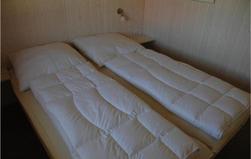 2 Betten in einem Zimmer mit weißer Bettwäsche in der Unterkunft Friedrichskoog-strandpark 7 in Friedrichskoog