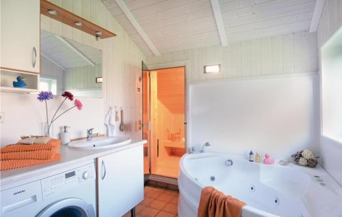 ein Badezimmer mit einer Badewanne, einem Waschbecken und einer Waschmaschine in der Unterkunft Friedrichskoog-strandpark 7 in Friedrichskoog