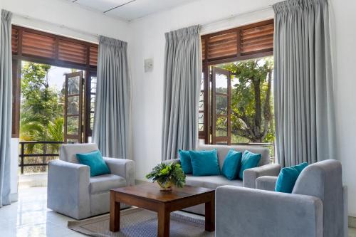 a living room with two couches and a table at Villa Sarakkuwa in Pamunugama