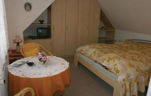 ein Schlafzimmer mit einem Bett und einem Tisch mit Blumen darauf in der Unterkunft Awesome Apartment In Elmenhorst-lichtenhag, With Kitchenette in Elmenhorst