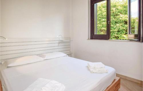 un letto bianco in una stanza con finestra di Stunning Home In Scicli Rg With Private Swimming Pool, Can Be Inside Or Outside a Donnalucata