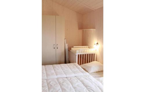 a bedroom with a white bed and a cabinet at Dnenpark 2d - Dorf 4 in Travemünde
