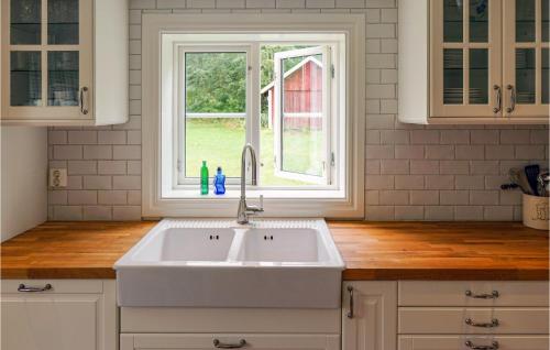 een witte keuken met een wastafel en een raam bij Beautiful Home In Vrnamo With Wifi in Värnamo
