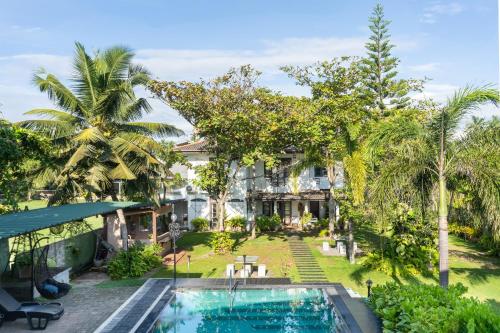 una vista aérea de una casa con piscina y palmeras en Villa Sarakkuwa, en Pamunugama