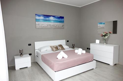a white bedroom with a bed and two white cabinets at Casa Marino -Al Castello- in Angri