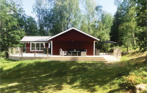 a small cabin with a deck in a yard at Lovely Home In Trosa With Kitchen in Trosa