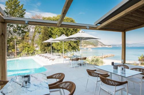 a patio with tables and chairs and a swimming pool at Alboro seaside suites in Parga