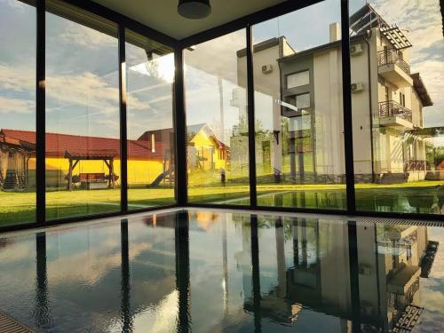 uma vista para uma piscina a partir da janela de uma casa em Pensiunea Casa Hortopan em Târgu Jiu