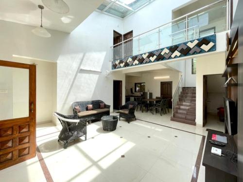a living room with a staircase and a dining room at Dream House Mahabaleshwar in Mahabaleshwar