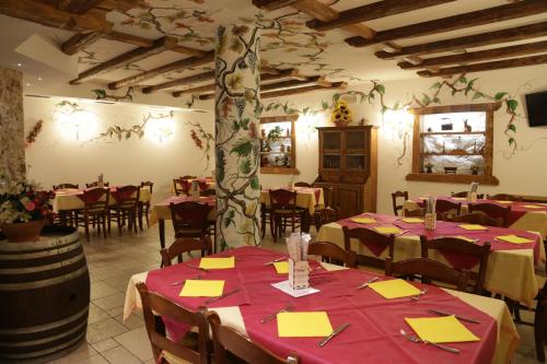 un restaurante con mesas y sillas en una habitación en B&B Casa Agostini, en Fai della Paganella