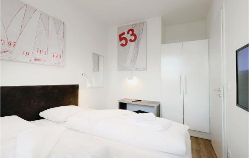 トラフェミュンデにあるAmazing Apartment In Lbeck Travemnde With 2 Bedrooms, Sauna And Wifiのベッドルーム(白いベッド2台、テレビ付)