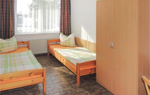 シュトラールズントにあるNice Home In Stralsund With Kitchenのツインベッド2台と窓が備わる客室です。